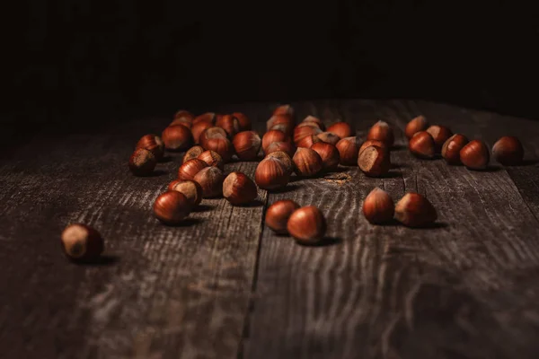 Крупный план орехов сена на деревянной поверхности на черном фоне — стоковое фото