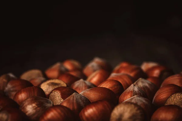 Close up view of shelled hazelnuts on black background — Stock Photo