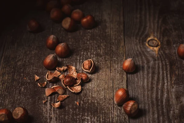 Close up view of shelled hazelnuts and husk on wooden tabletop — Stock Photo