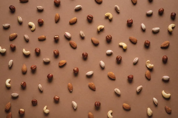 Повна рамка з різних горіхів, розташованих на коричневому тлі — стокове фото