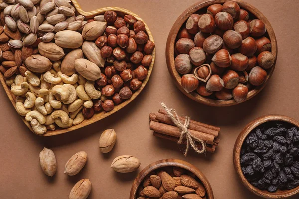 Flat lay with variety of nuts in bowls arranged on brown background — Stock Photo