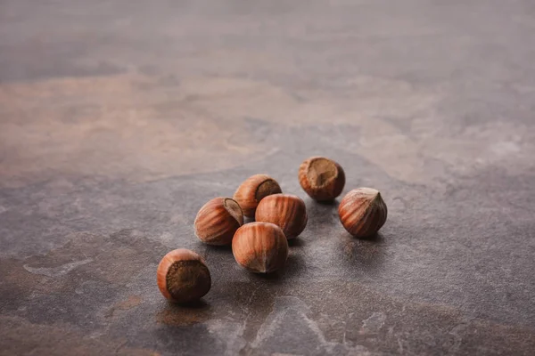 Close up view of shelled hazelnuts on grey tabletop — Stock Photo