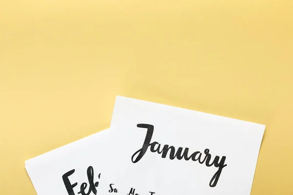 Close-up view of papers with january and february calendar on beige background — Stock Photo