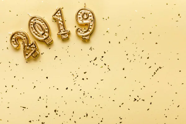 Top view of 2019 candles and golden confetti on beige background — Stock Photo