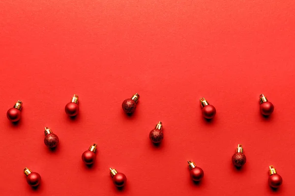 Boules de Noël festives brillantes sur fond rouge — Photo de stock