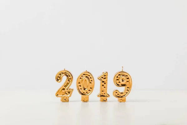 Brilhante dourado 2019 números velas no fundo branco — Fotografia de Stock
