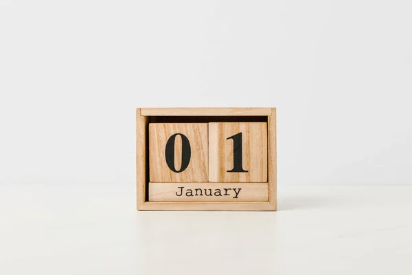 Primo piano calendario in legno con 01 gennaio su sfondo bianco — Foto stock