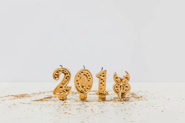 2018 candles and golden confetti on white background — Stock Photo