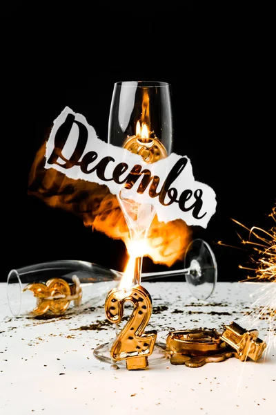 Papier mit Dezemberbeschriftung, Gläsern und Zahlen 2019 mit Kerzen auf Schwarz — Stockfoto