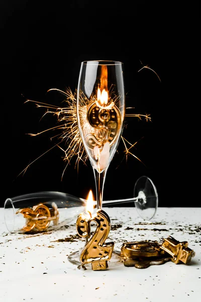 Bicchieri di champagne, brillantini e numeri dorati 2019 su nero — Foto stock