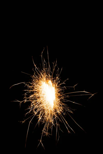 Close-up view of bright glowing new year sparkler on black background — Stock Photo