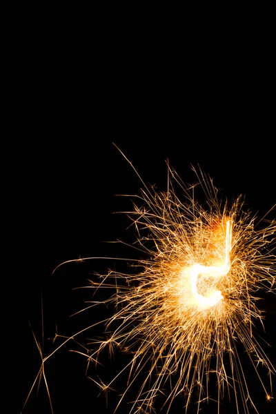 Bright burning christmas sparkler on black background — Stock Photo