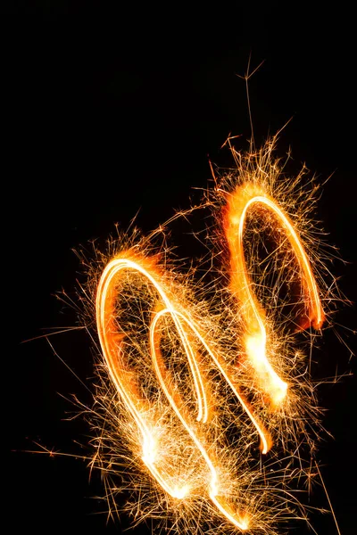 Close-up view of burning new year sparkler on black background — Stock Photo