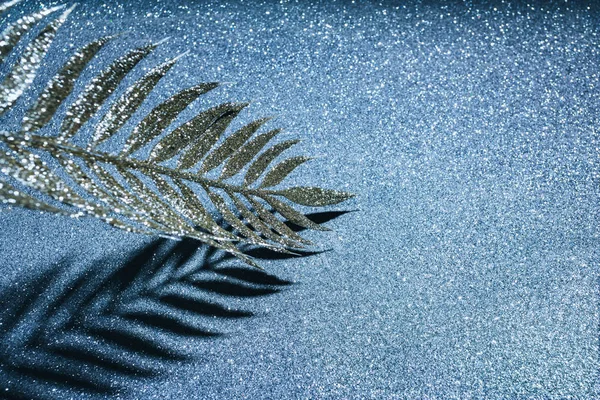 Vue rapprochée de la branche festive décorée de paillettes dorées et d'ombre sur une surface scintillante, concept de fond de Noël — Stock Photo