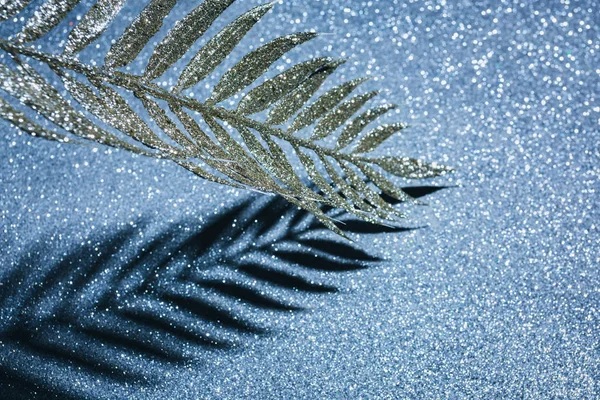 Zweig mit goldenem Glanz und Schatten auf glitzernder Oberfläche, weihnachtliches Hintergrundkonzept — Stockfoto