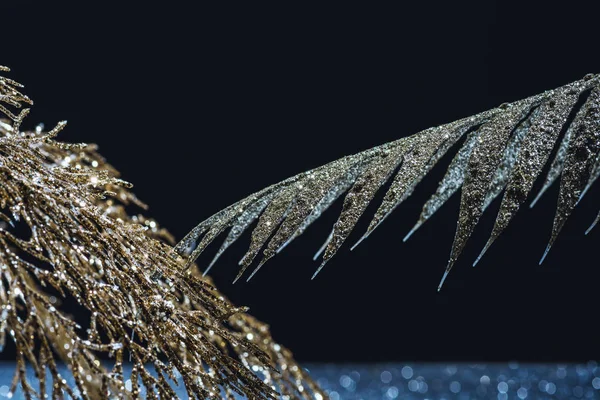 Close up view of festive branches decorated by golden glitter on black — Stock Photo