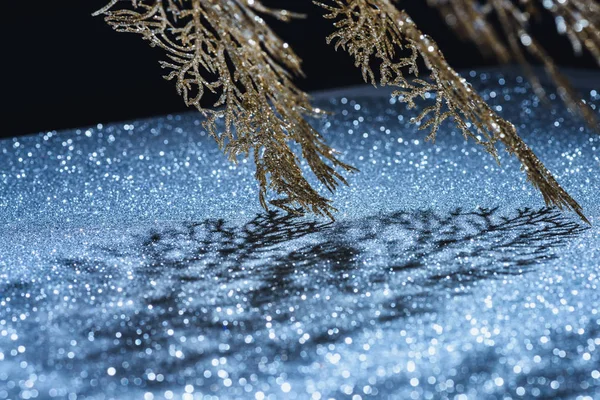 Selektiver Schwerpunkt des festlichen Zweiges mit goldenem Glanz und Schatten, weihnachtliches Hintergrundkonzept — Stockfoto