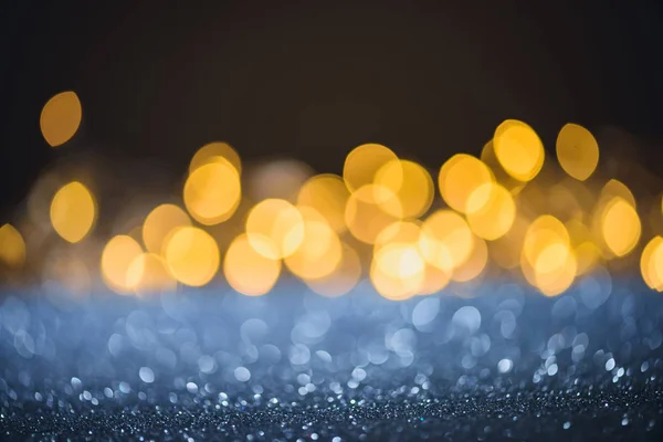 Selective focus of blurred sparkling lights and bokeh on black — Stock Photo