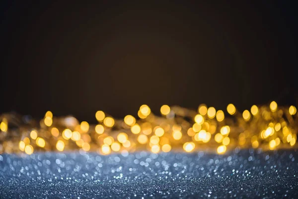 Selective focus of blurred sparkling lights and bokeh on black — Stock Photo
