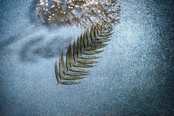 Top view of festive branches decorated by golden glitter on sparkling surface — Stock Photo