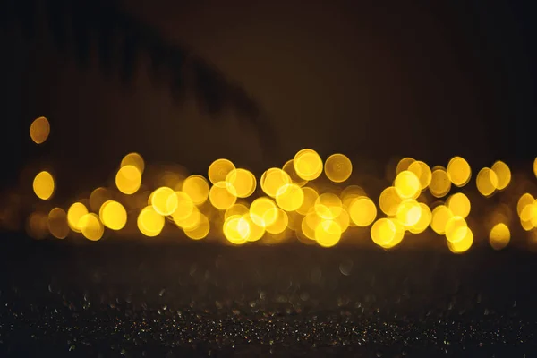 Selective focus of branch, blurred sparkling lights and bokeh on black — Stock Photo