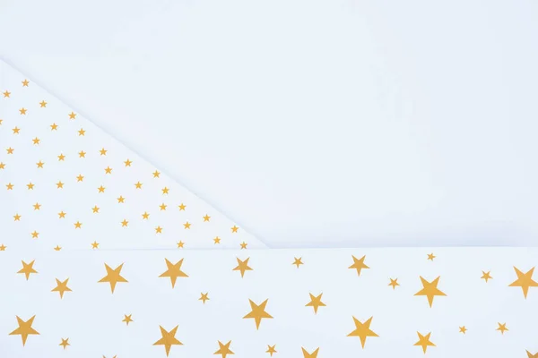 Vista superior de papel festivo decorado con estrellas doradas aisladas en blanco - foto de stock