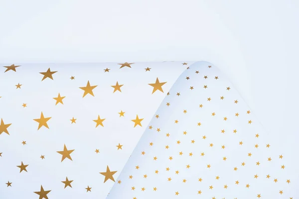 Vista desde arriba de papel festivo decorado por estrellas doradas aisladas en blanco - foto de stock