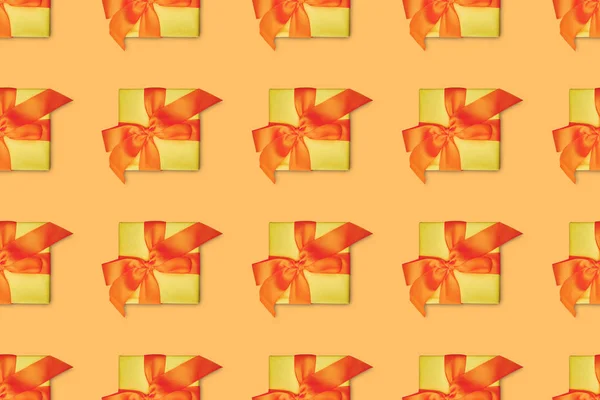 Fondo naranja sin costuras con regalos de Navidad amarillos con arcos - foto de stock
