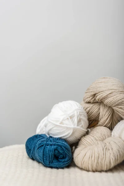 Close up view of arranged yarn clews on woolen surface on grey background — Stock Photo