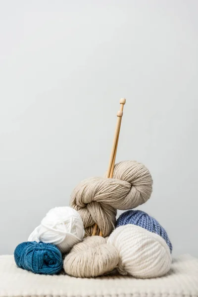 Close up view of knitting clews with knitting needles on grey backdrop — Stock Photo