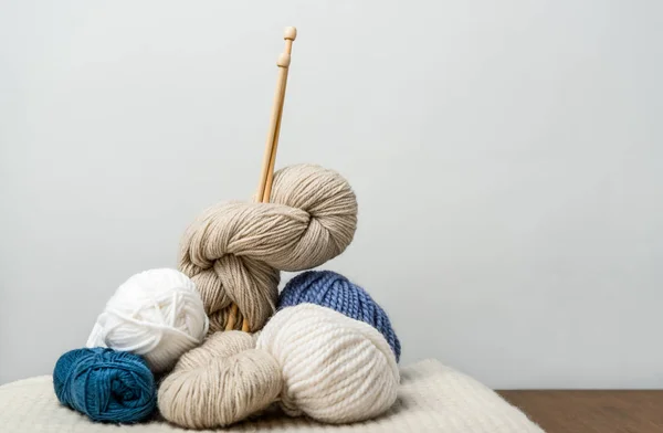 Close up view of knitting clews with knitting needles on grey backdrop — Stock Photo