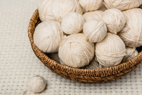 Close up view of yarn balls in wicker basket on white backdrop — Stock Photo