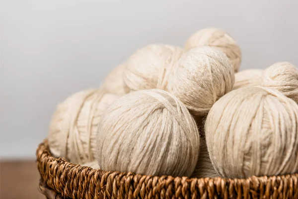 Close up view of yarn balls in wicker basket on grey background — Stock Photo