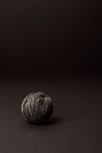 Vista de perto da bola de tricô cinza no fundo escuro — Fotografia de Stock