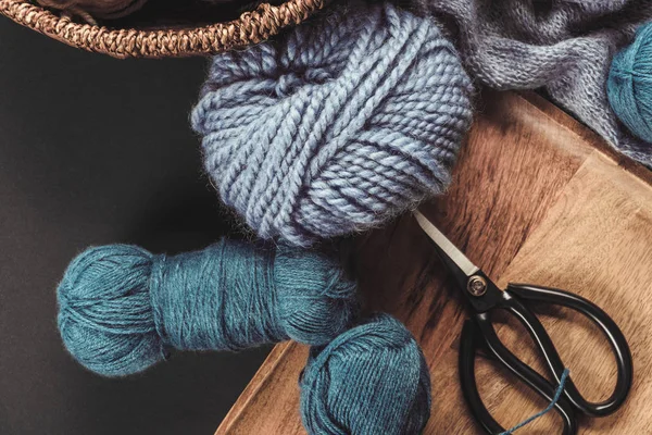 Tendido plano con bolas de hilo púrpura y azul con tijeras sobre fondo gris - foto de stock