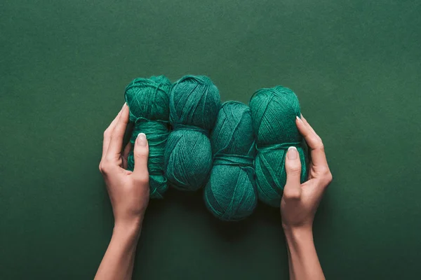 Cropped shot of woman holding yarn on green backdrop — Stock Photo