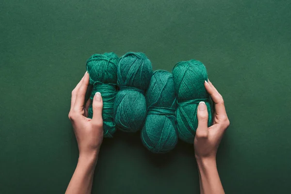 Tiro recortado de mujer sosteniendo hilo sobre fondo verde - foto de stock