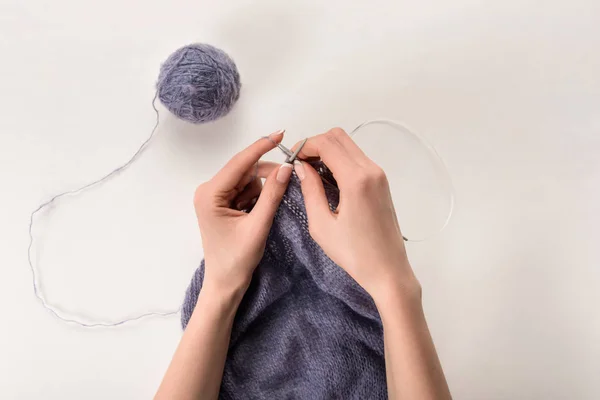 Partial view of woman knitting yarn on grey backdrop — Stock Photo