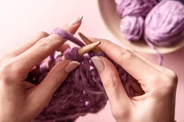 Partial view of woman knitting yarn on pink background — Stock Photo