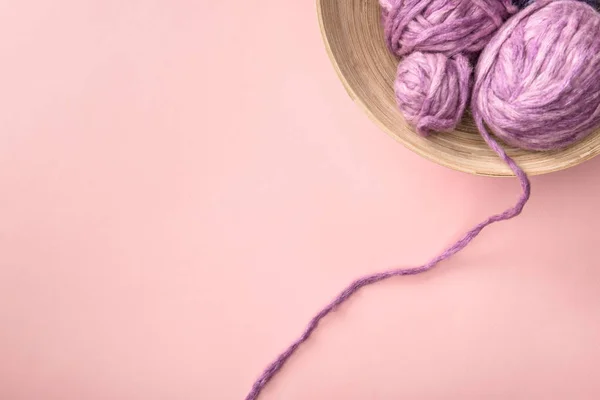 Vista dall'alto del lavoro a maglia viola in ciotola sul tavolo rosa — Foto stock