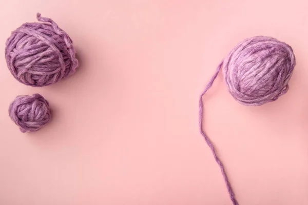 Top view of purple knitting balls on pink tabletop — Stock Photo