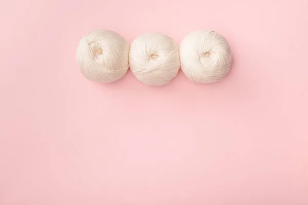 Top view of white knitting clews on pink tabletop — Stock Photo