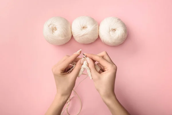 Partial view of woman knitting yarn on pink background — Stock Photo