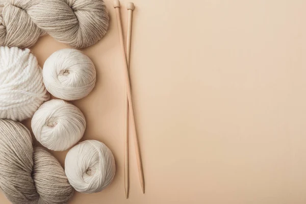 Flat lay with yarn and knitting needles on beige backdrop — Stock Photo