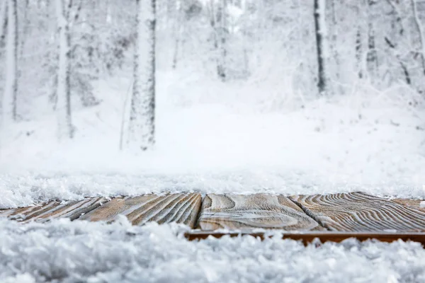 Уровень поверхности полосатой коричневой деревянной дорожки и красивый зимний лес — стоковое фото