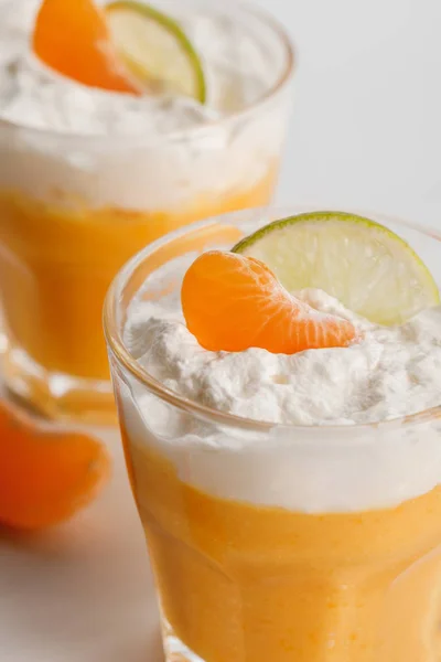Perto de copos com mousse de laranja com tangerina e fatias de limão — Fotografia de Stock