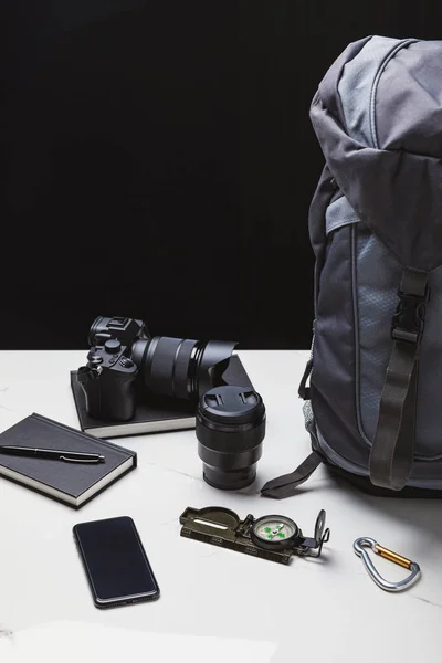 Mochila, smartphone, cámara fotográfica con lente y equipo de seguimiento - foto de stock