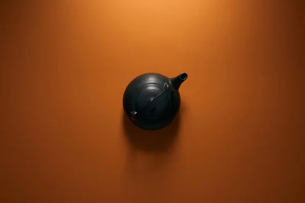 Top view of black ceramic teapot on brown background — Stock Photo