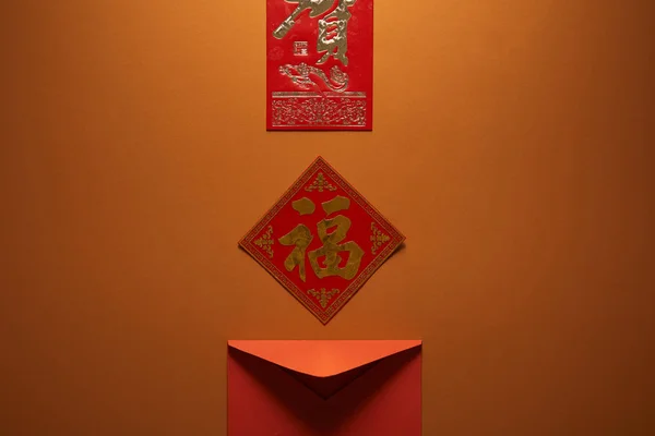 Червоний конверт та ієрогліфи на коричневому фоні, китайська концепція нового року — стокове фото