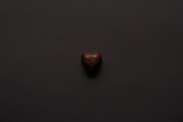 Top view of tasty chocolate heart on black background — Stock Photo